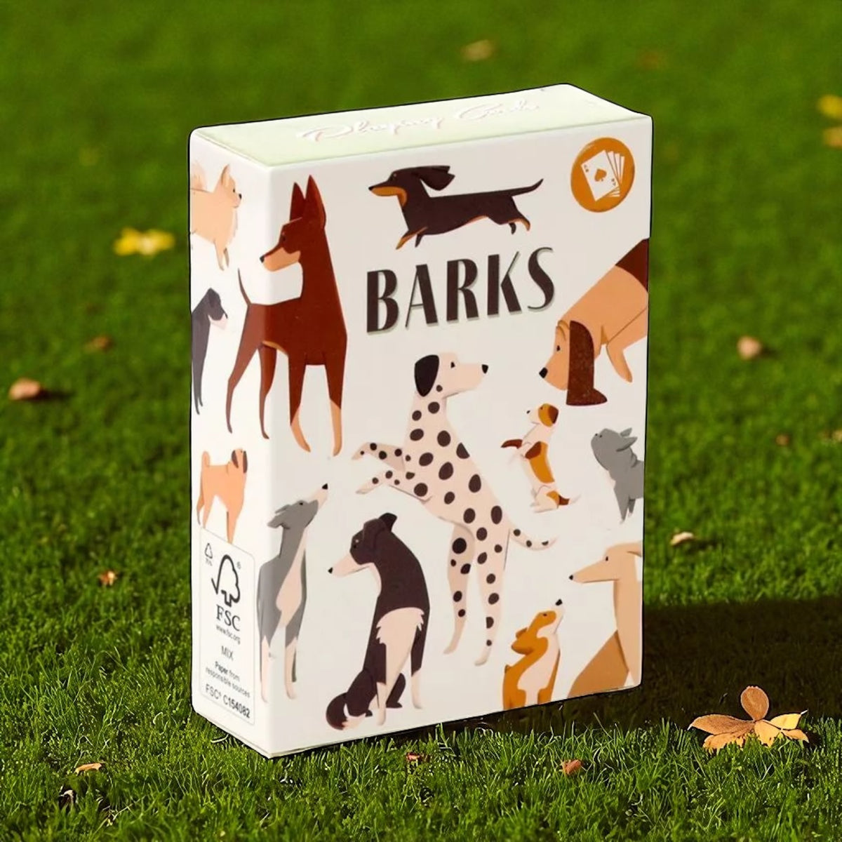 Barks playing card tuck box featuring illustrations of different dog breeds, standing on green grass with scattered leaves.