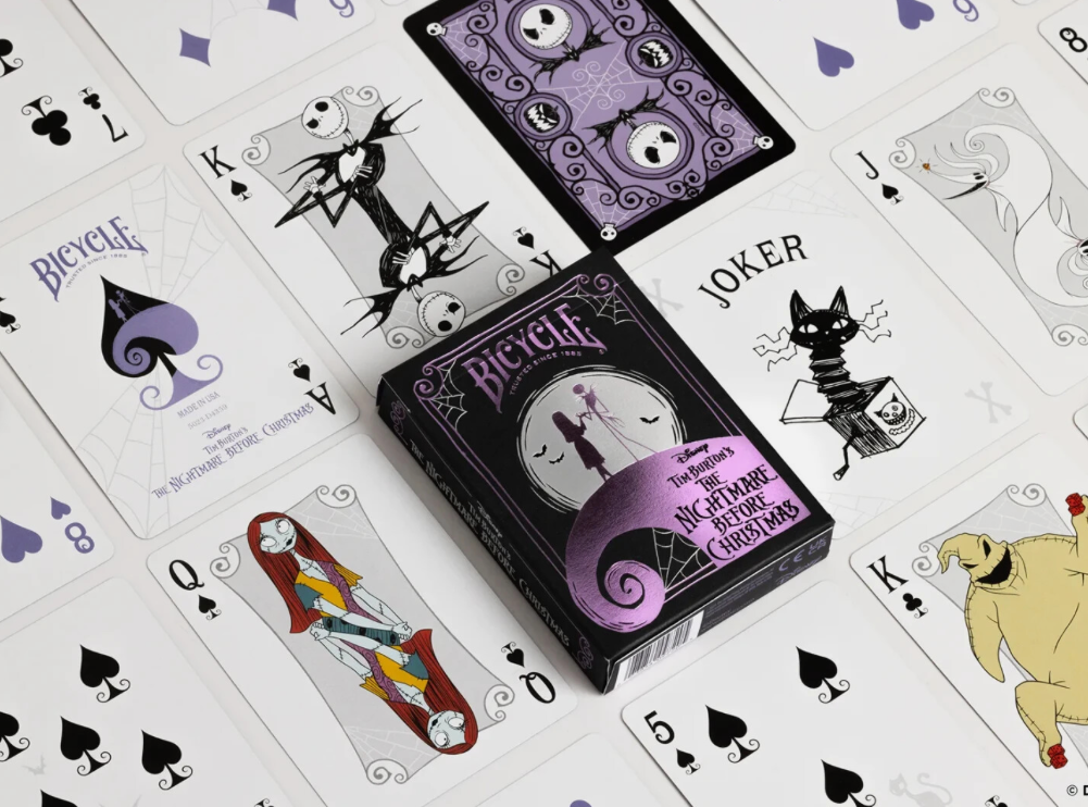 Bicycle Disney The Nightmare Before Christmas playing card deck surrounded by custom cards featuring Jack Skellington, Sally, Zero, Oogie Boogie and a black cat Joker, with purple card backs.