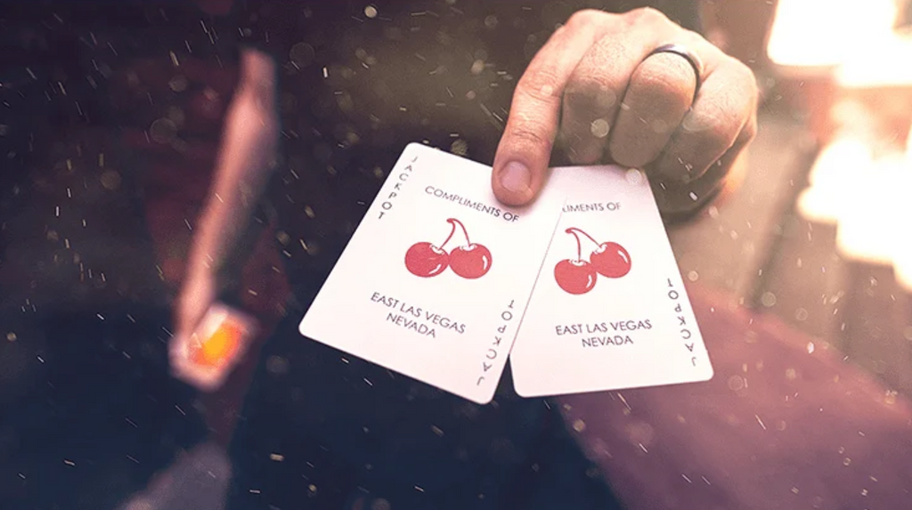 Two custom Joker cards from Cherry Casino Summerlin Sunset Orange Playing Cards, featuring red cherry artwork and East Las Vegas Nevada lettering, held side by side.