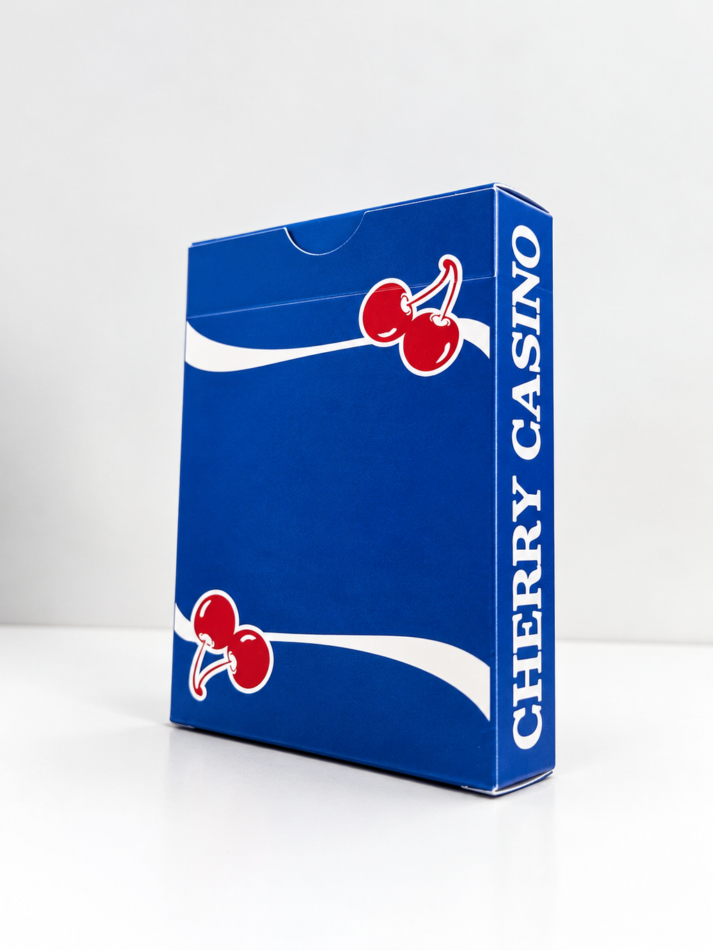 Angled view of Cherry Casino Tahoe Blue Playing Cards showing the vibrant blue tuck box, red cherry artwork, flowing white stripes and Cherry Casino lettering along the side.