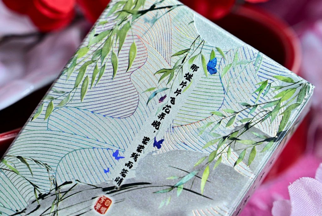 Four Beauties Spring Playing Cards showing the decorative back of the tuck box with Chinese calligraphy, green bamboo leaves, blue butterflies and shimmering metallic foil detailing.