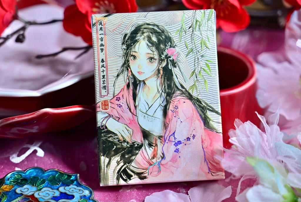 Four Beauties Spring Playing Cards featuring an illustrated Chinese woman in a pink traditional dress, photographed with cherry blossoms, a red teacup and oriental accessories.