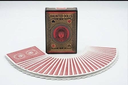 Haunted Dolls Playing Cards by CPC showing the ornate gothic tuck box behind a fan of red patterned playing card backs on a white background.