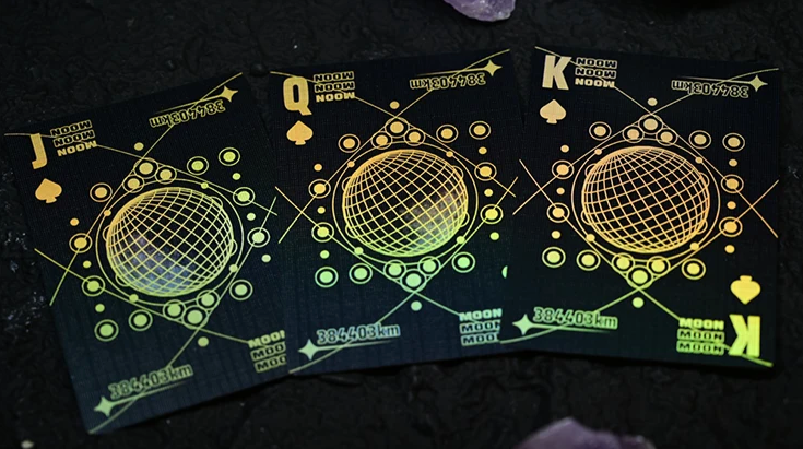 Moon Black Holo Playing Cards by Hiddenlight showing custom Jack, Queen and King of Spades with black backgrounds, holographic gold and green geometric patterns and central wireframe lunar sphere designs.