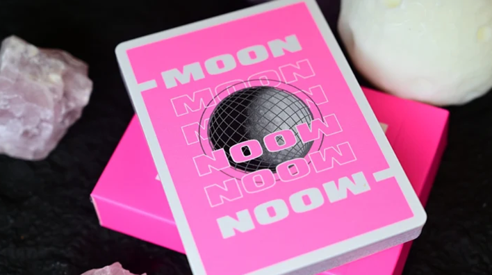 Moon Pink Standard Playing Cards by Hiddenlight showing the custom neon pink card back design with bold white MOON lettering, a black wireframe sphere and white borders, displayed on the matching tuck box.