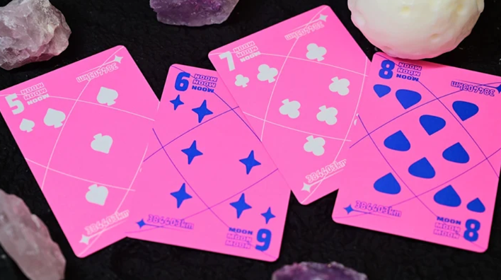 Moon Pink Standard Playing Cards by Hiddenlight showing the custom 5, 6, 7 and 8 number cards with vibrant neon pink backgrounds, blue and white suit symbols and geometric lunar-inspired artwork.