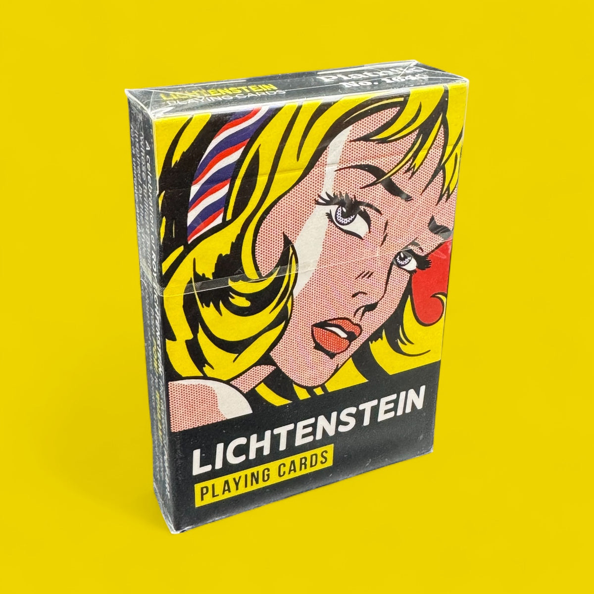Piatnik Roy Lichtenstein Playing Cards in a yellow tuck box featuring colourful Pop Art comic-style artwork of a blonde woman.