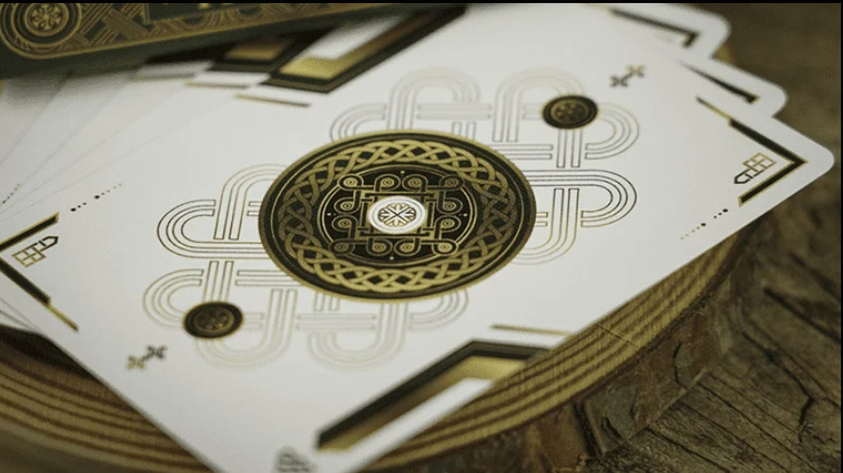 Close-up of Trend Green Playing Cards by TCC, showing the minimalist white card faces with ornate gold and black circular artwork and geometric detailing