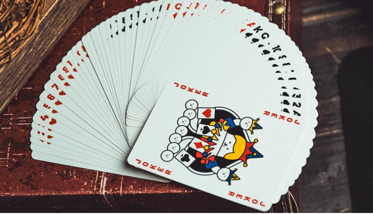 WHIKO Stage Thin Playing Cards by Bacon Magic displayed in a wide fan, showing the playing card faces and colourful custom Joker artwork featuring the WHIKO character.