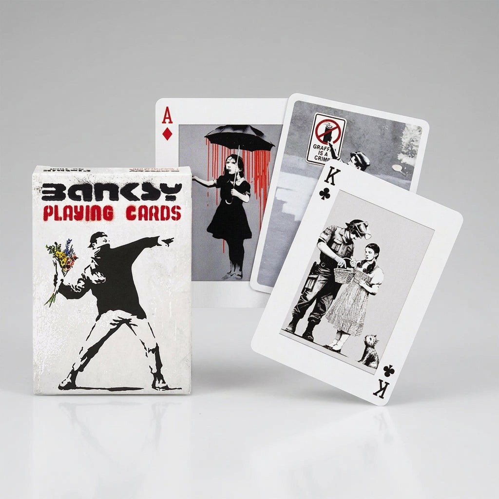Piatnik Banksy First Collection playing card box featuring the flower thrower, alongside cards showing a girl with an umbrella, graffiti artwork and a soldier searching a girl