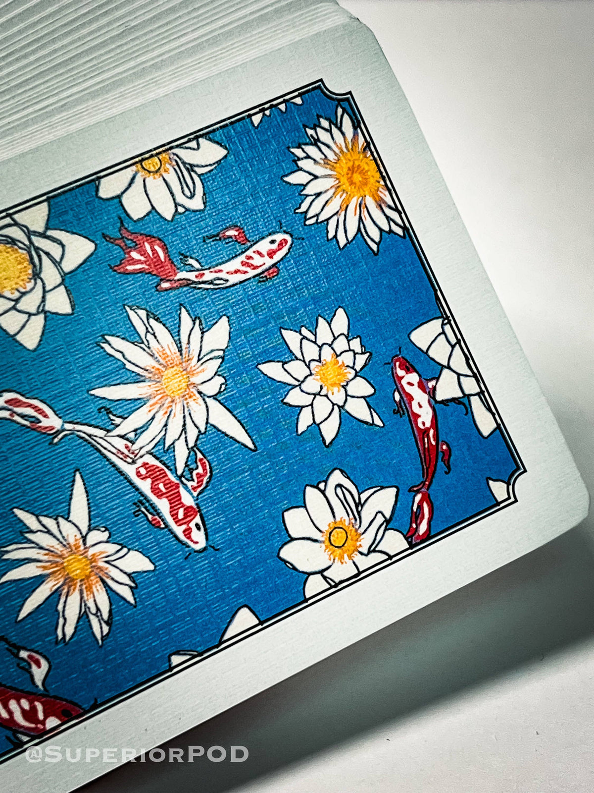 Playing card with koi fish and flower design on a blue background